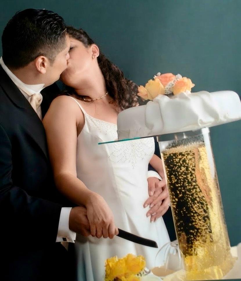 Newlyweds kissing while cutting the wedding cake